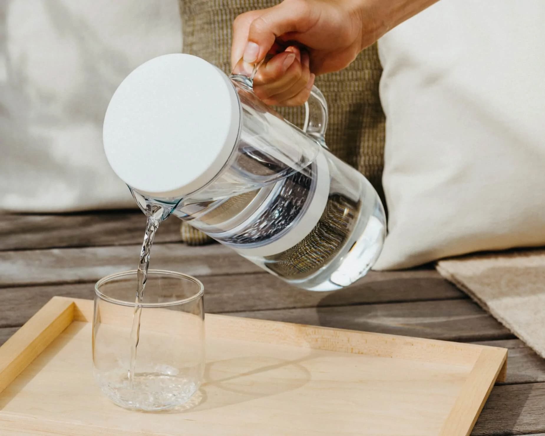 LUCY® Filter Carafe aus der ein Glas Wasser eingeschenkt wird