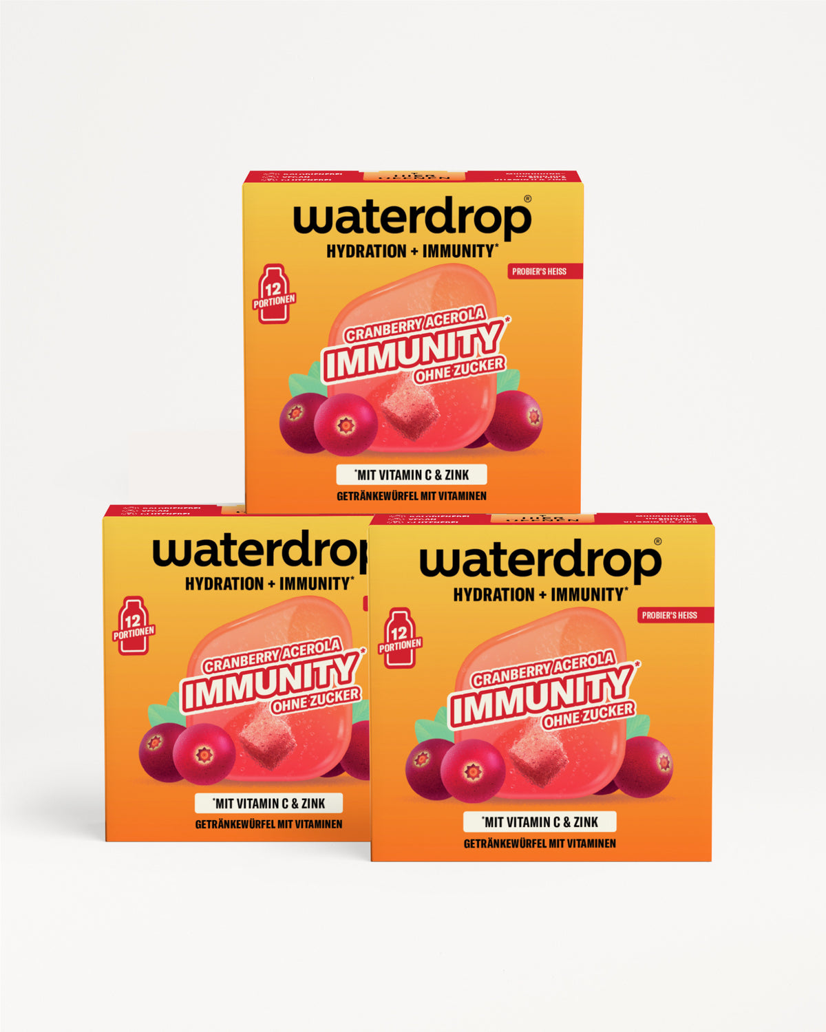 Drei orangefarbene und gelbe Boxen in pyramidaler Anordnung vor weißem Hintergrund.