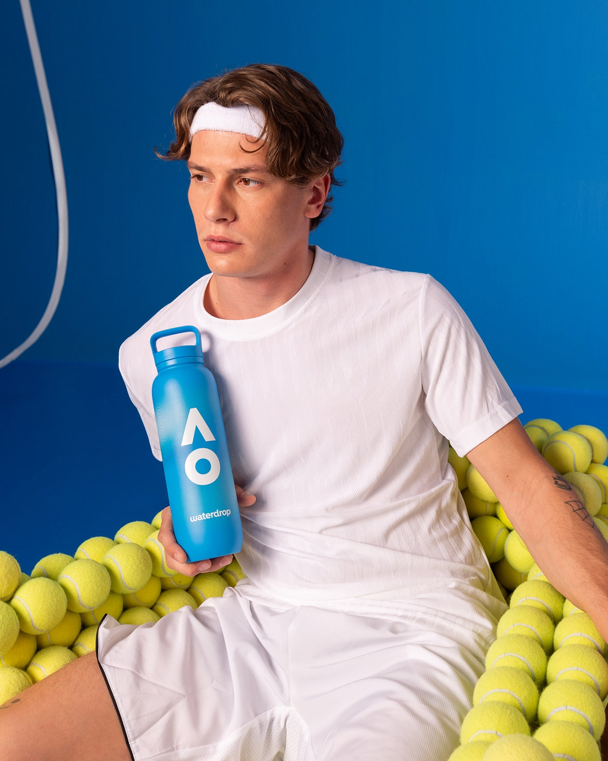 AO26 Official Player Bottle mit Tennisspieler und gelben Bällen.