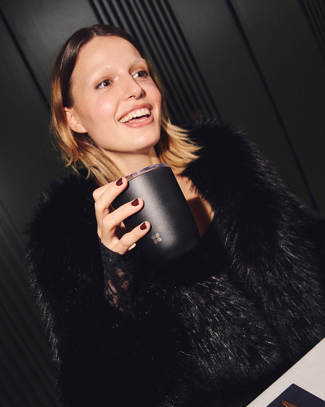 Frau hält Steel Cup in stilvollem Ambiente.