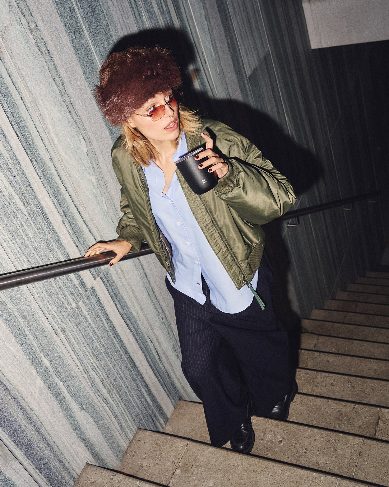 Person mit Steel Cup auf Treppe.