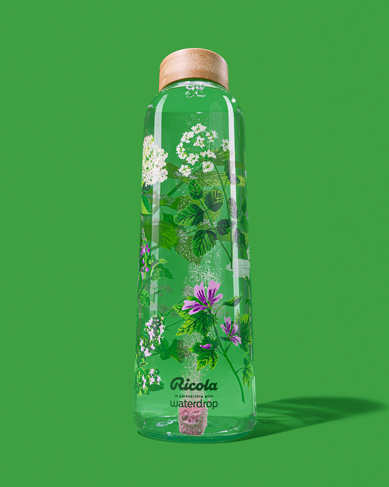 Ricola Edition Glassflasche mit botanischem Print und sprudelndem Würfel.