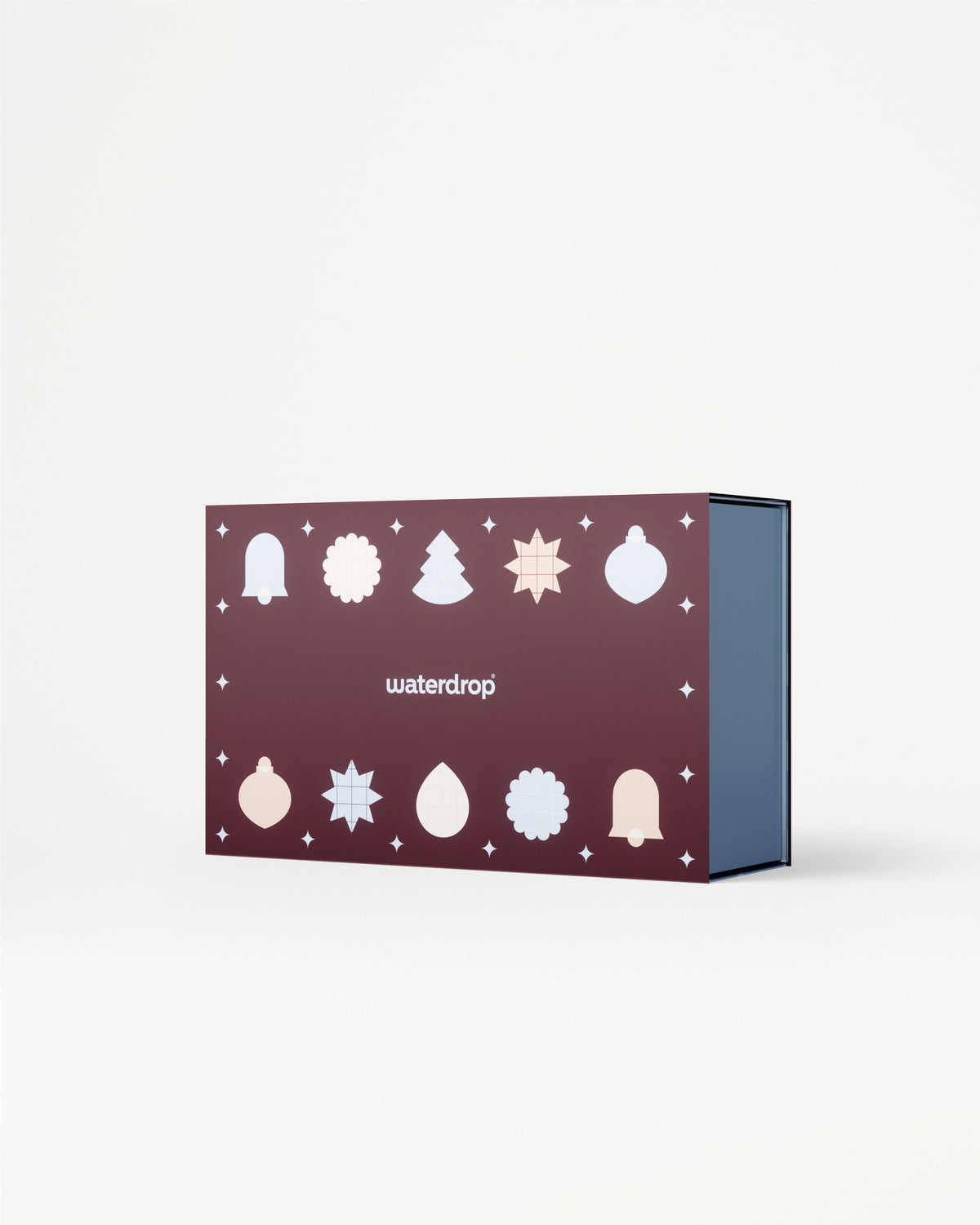 Lila Geschenkkarton mit weißen Weihnachtsmotiven auf dem Deckel und blauem Innenraum.