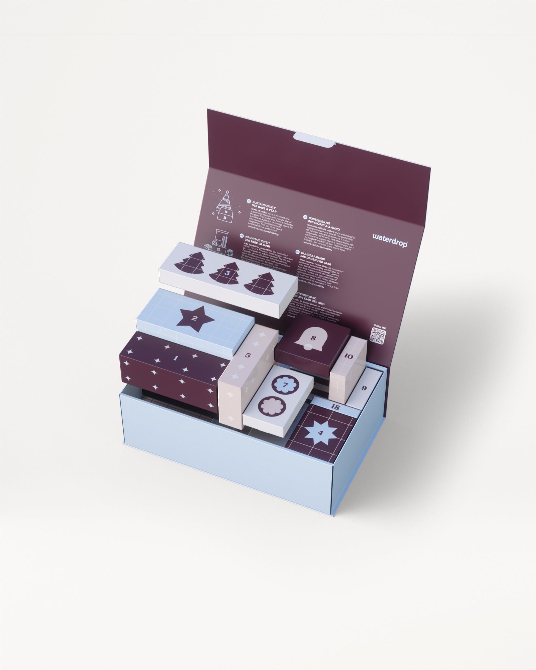 Dreistufige hellblaue Geschenkverpackung mit lila Deckel geöffnet, um mehrere kleine dekorative Boxen in passenden Farben zu enthüllen.