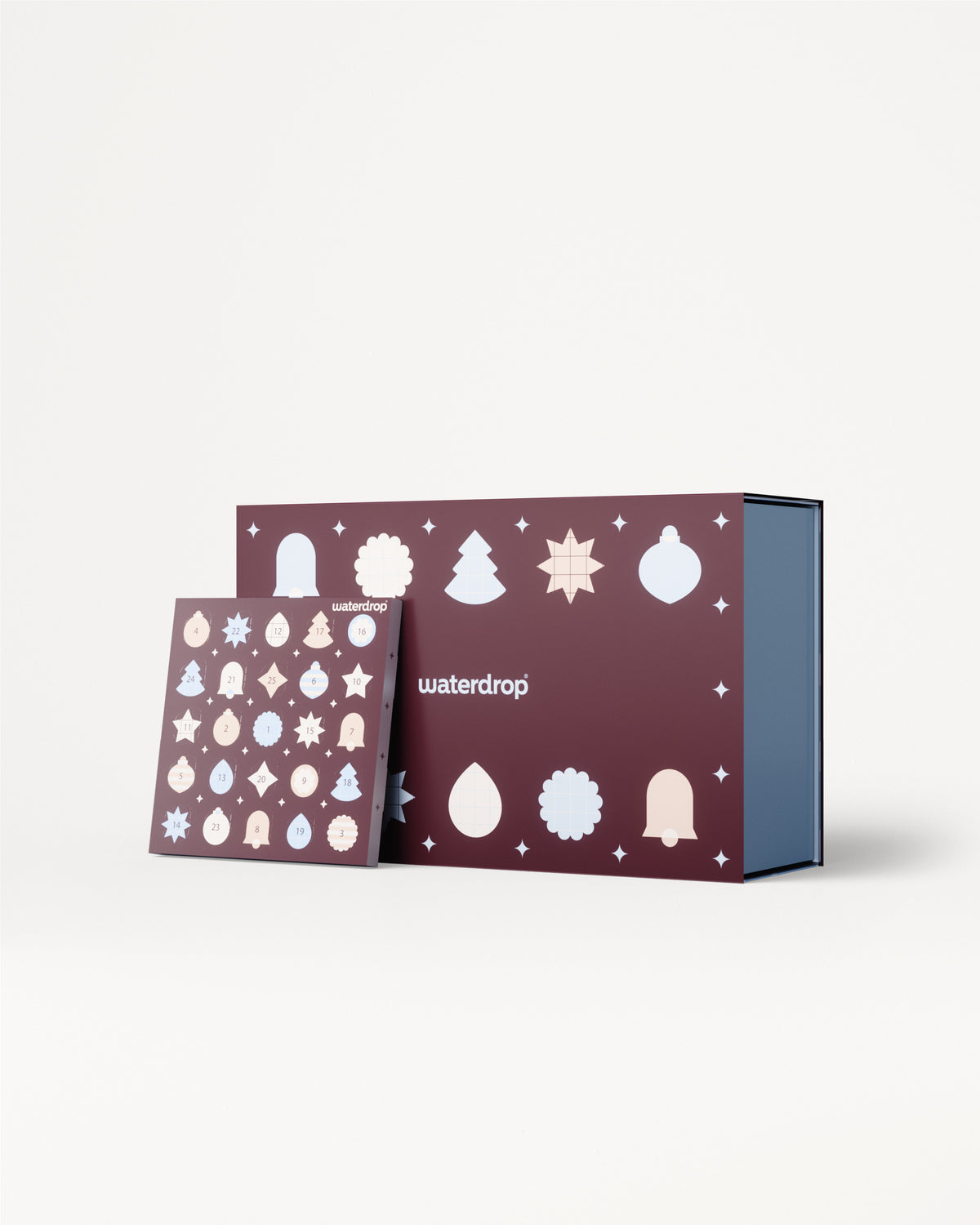 Adventskalender mit violetten Tafeln und weißen Weihnachtsornamenten, abgebildet mit blauem Innenfach.
