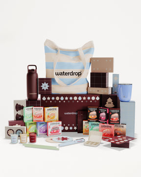Sortiment verpackter Produkte rund uma gestreifte Einkaufstasche als Geschenkset.