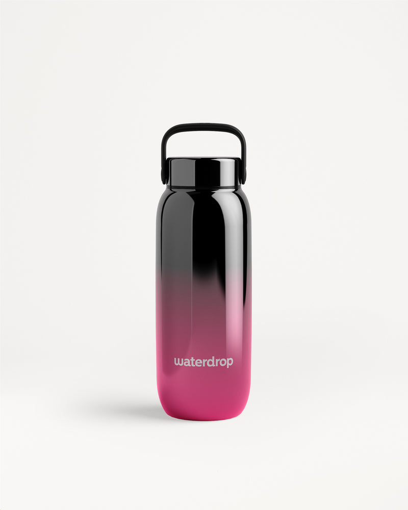 Wasserflasche mit Farbverlauf von Schwarz zu Pink, mit schwarzer Deckel und Trageschlaufe.