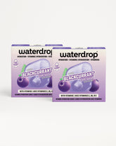 Zwei lila Waterdrop Verpackungen mit Beerenmotiv.