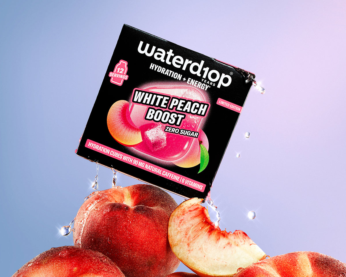 Verpacktes Getränkeprodukt zur Hydratation und Energie auf einem Haufen Pfirsiche mit Wassertropfen, Hintergrund in Pink-Blau-Verlauf.