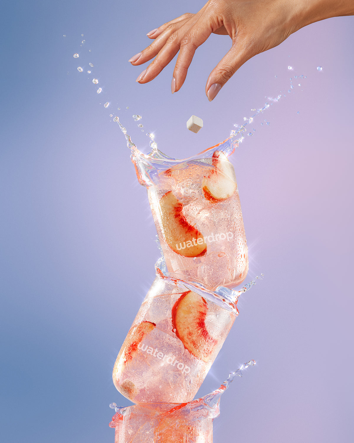 Gestapelte Eiswürfel mit Erdbeerscheiben und eine Hand, die einen Würfel hineinlässt, Wasserspritzer.