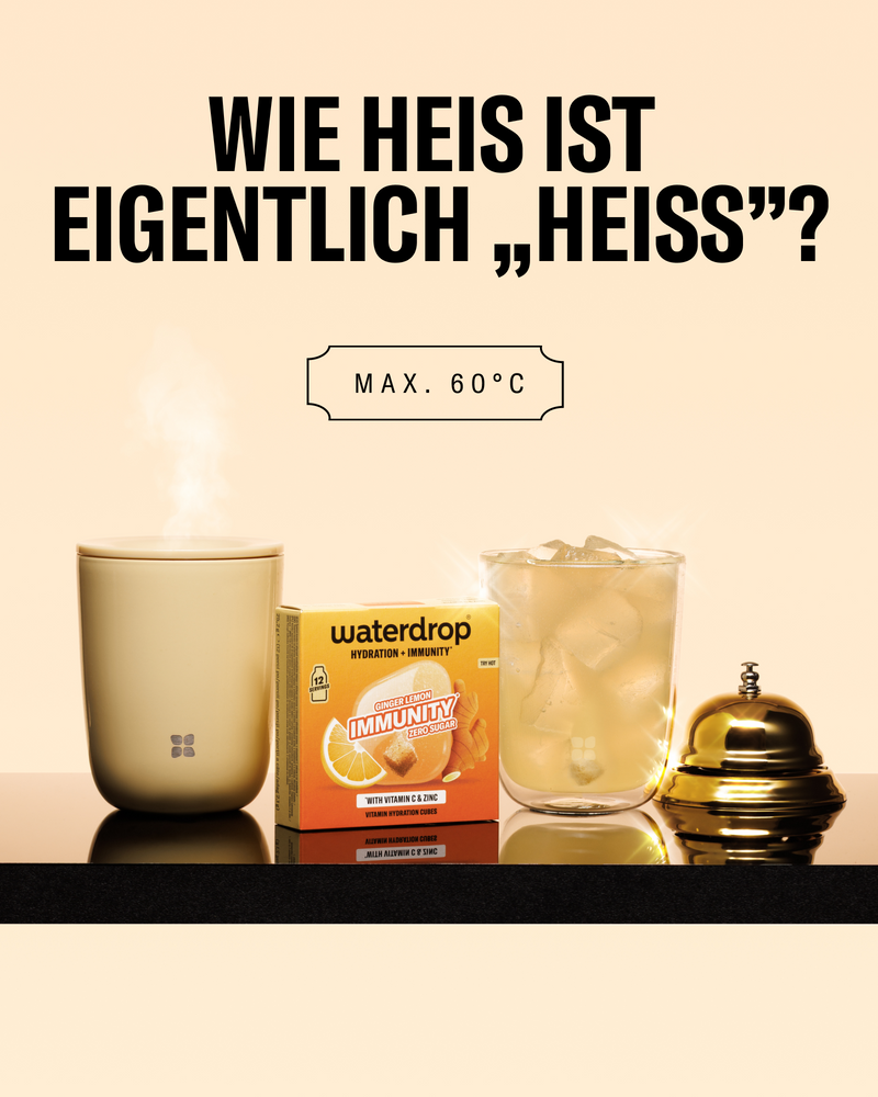 Set warmer Getränke auf einer reflektierenden Oberfläche, mit dampfender Tasse, einer Box, einem Glas mit Eiswürfeln und einem Deckel.