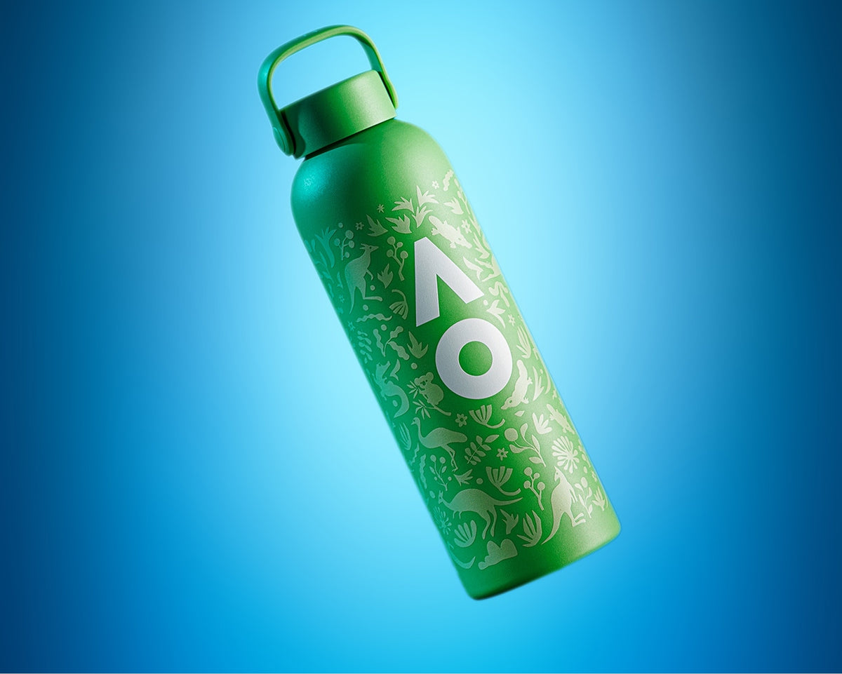 Grüne wiederverwendbare Wasserflasche mit Griffdeckel und weißen Mustern vor blauem Hintergrund.