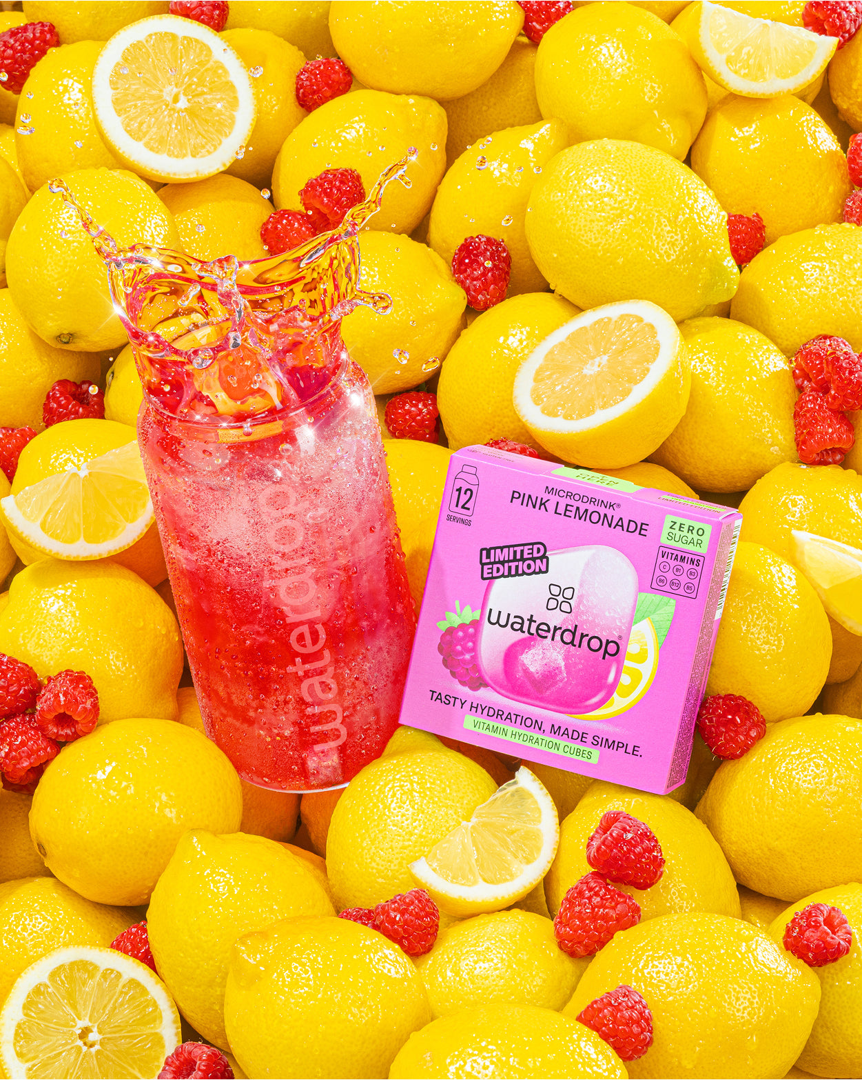 Pinke Limonade Flasche und Waterdrop-Verpackungsschachtel zwischen gelben Zitronen.