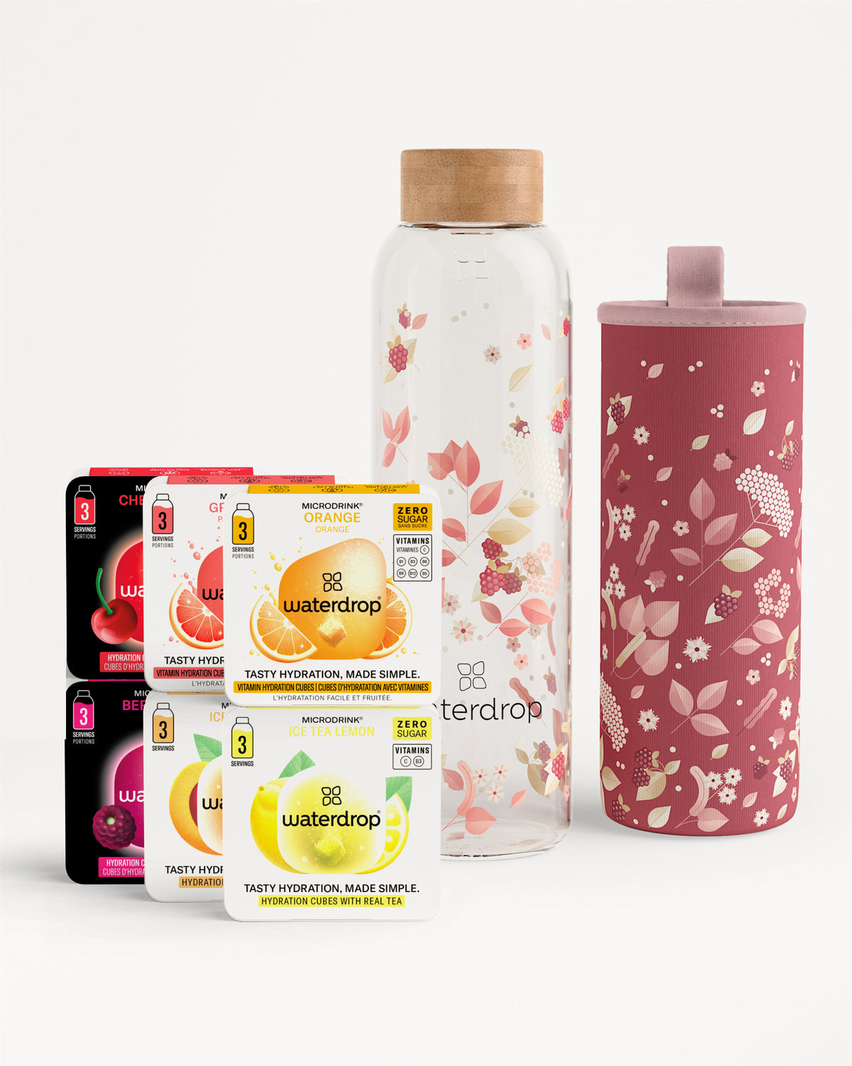 Auswahl an Waterdrop Getränkepäckchen, daneben eine Glasflasche mit Holzdeckel und eine pinke Thermohülle mit Blumenmuster.