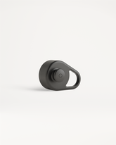 Pull-Up Cap: Matte-schwarzer Bluetooth-Tracker mit integriertem Loop und Knopf.