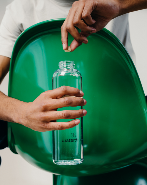 Person holding a waterdrop® Starter Set Microdrink Glass Bottle, showcasing the product's ergonomic design and high-quality borosilicate glass.