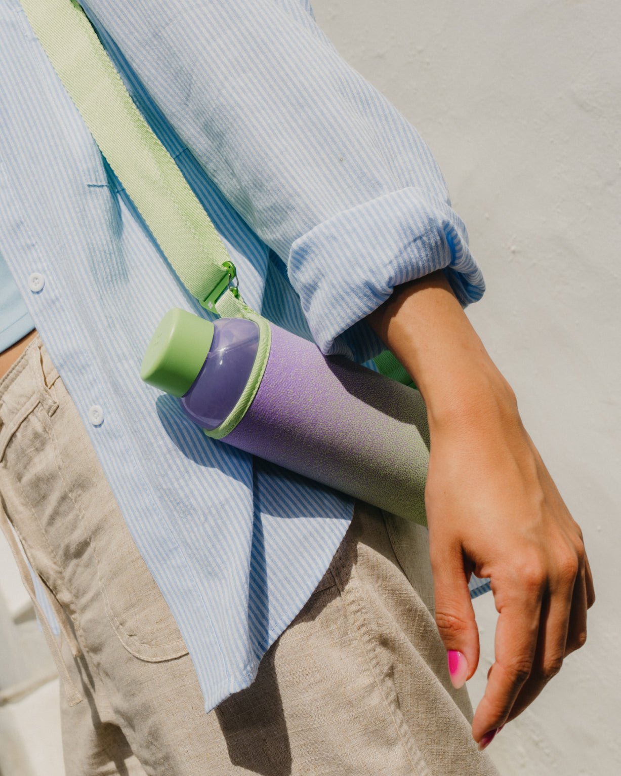 Bottle Sleeve Strap an Hand befestigt, beim Tragen der Wasserflasche.